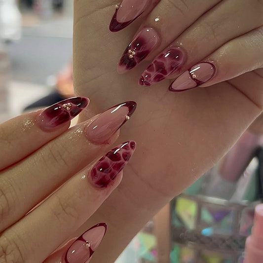 Handmade burgundy French tip press-on nails with minimalist petal art